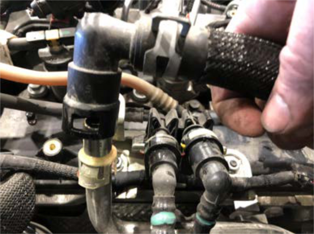 Release the coolant quick-connect on the driver side of the engine
