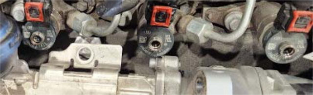 Disconnect the fuel return line quick-connects on top of the injectors