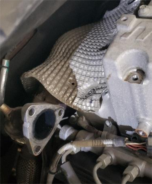 Swing the large rear heat shield out of the way